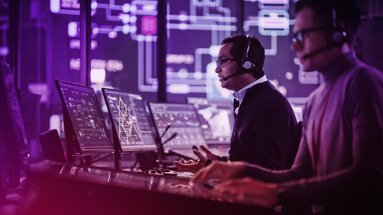 Two engineers working with multiple computer monitors