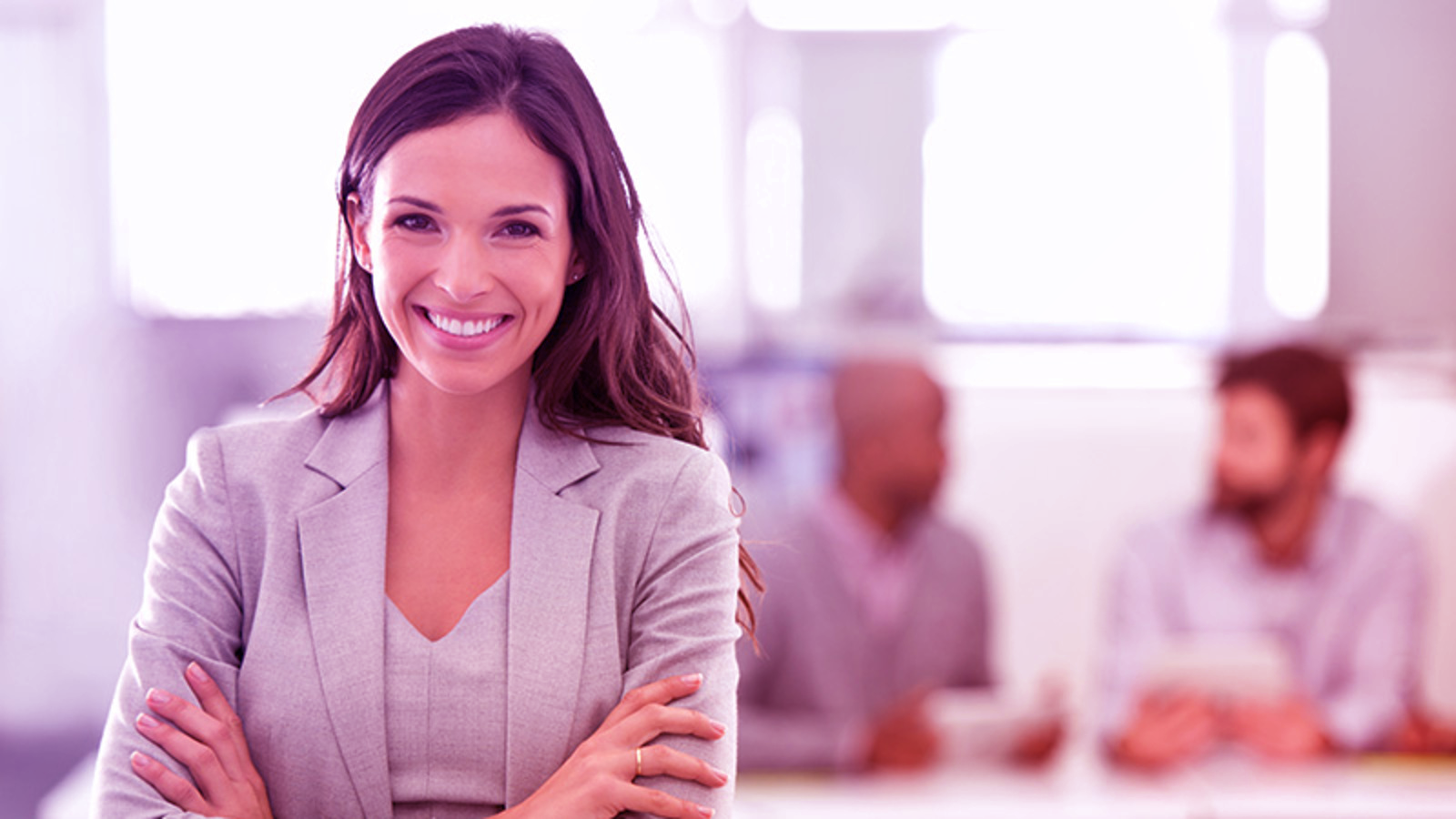 Expert smiling with arms crossed in office setting