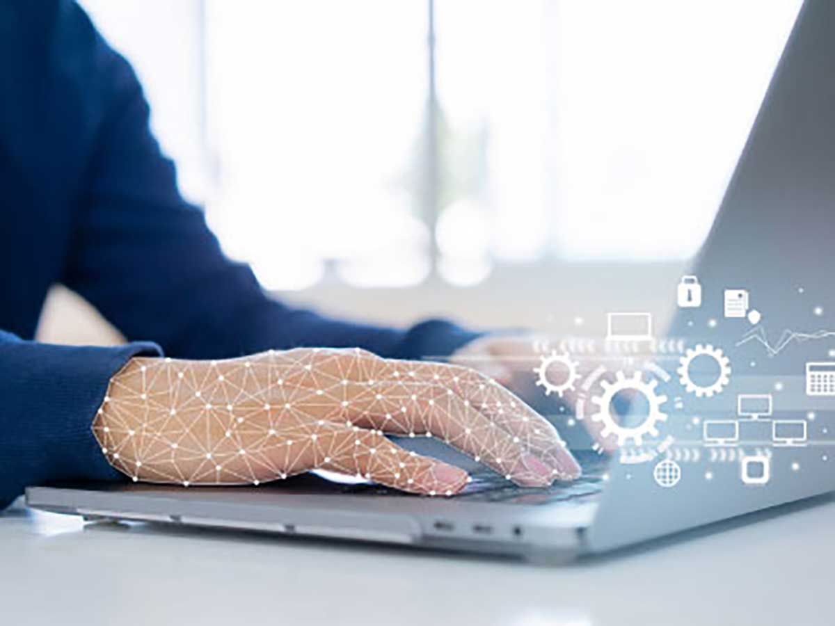 Hands typing on a laptop with futuristic gear symbols rising from keyboard