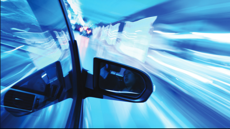 快速行驶的汽车，在反光镜中看到了乘客