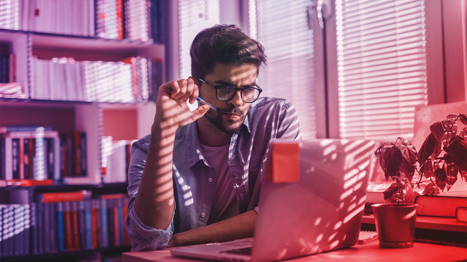 Two developers sit in front of computer with one pointing at screen