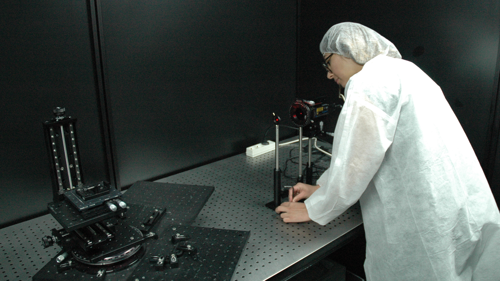Optical engineer performs optical scattering measurement using high specular bench