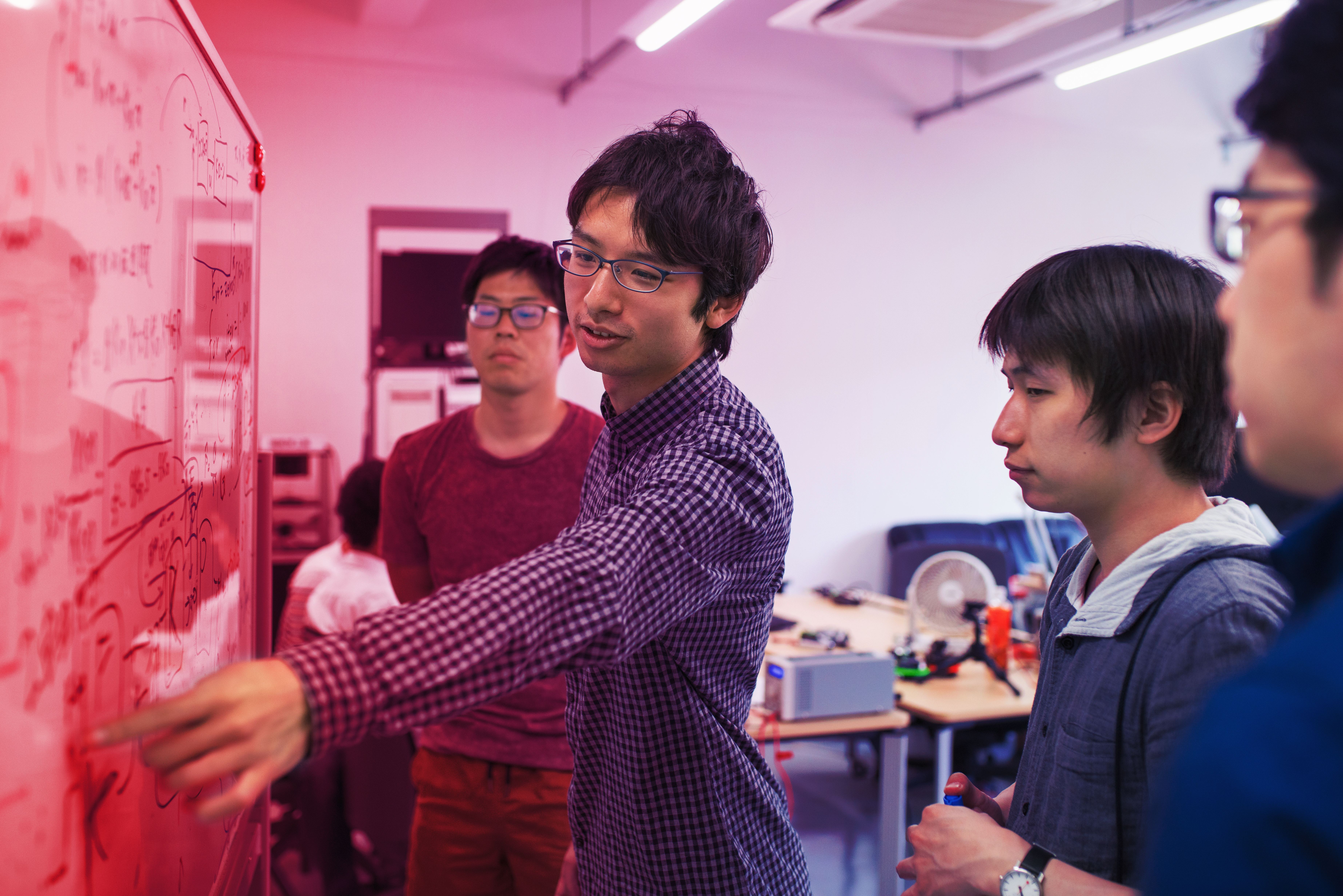 Three workers collaborate with tech graphics overlaid